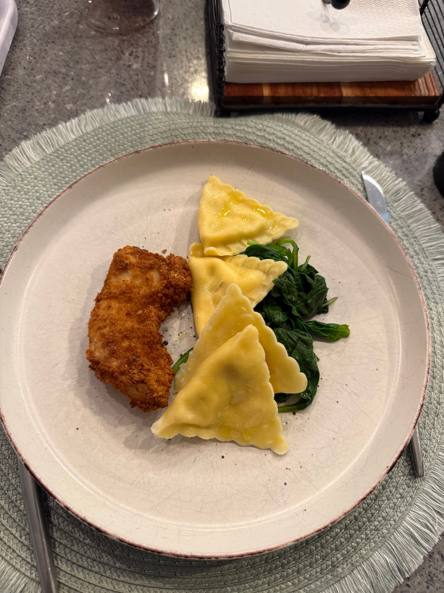 Pre-ride plate with breaded chicken, cheese-filled pasta, and sautéed spinach — a practical carbohydrate-forward meal a few hours before a hard training session