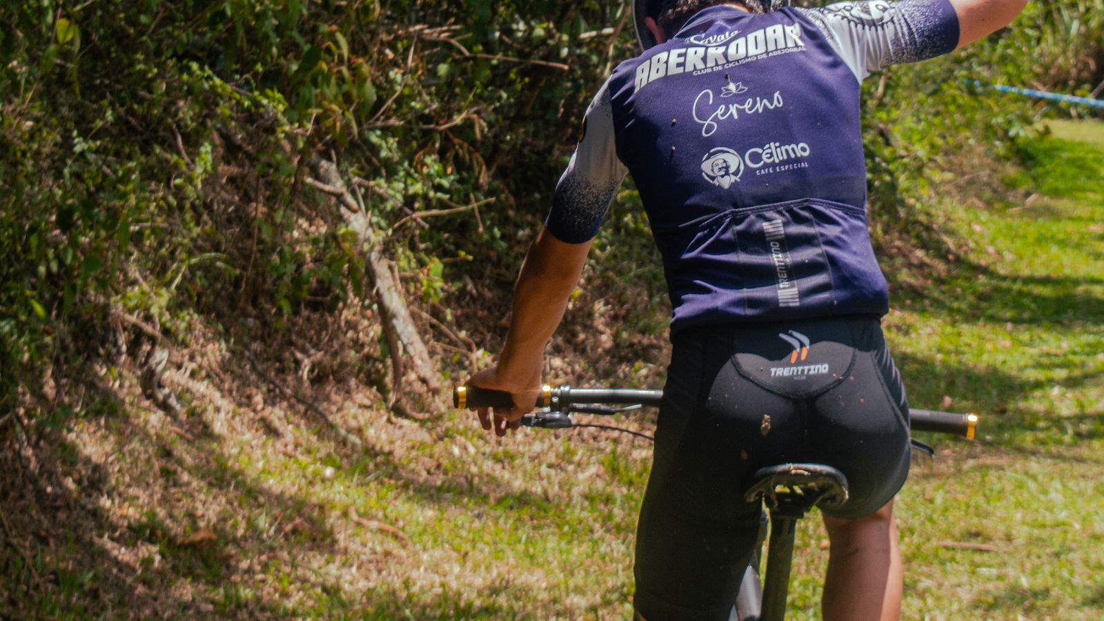 Cyclist adding an electrolyte tablet to a water bottle on a bike at golden hour