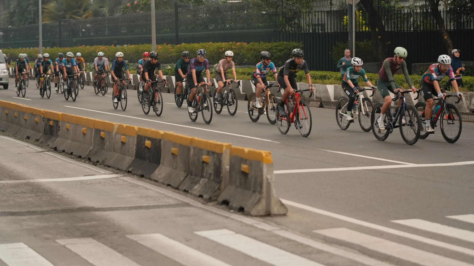 Competitive cyclists racing on a city-center criterium course, illustrating the fast, punchy start that a targeted warm-up prepares you for