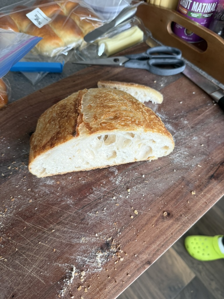 Fresh sliced sourdough bread on a wooden cutting board — an easy-to-digest, carbohydrate-rich option for the pre-race meal