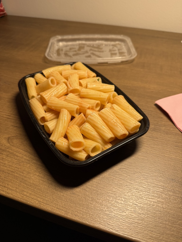Portion of plain rigatoni pasta in a meal-prep container — a classic night-before carbohydrate load for endurance racing